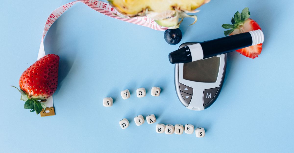 Digital clock showing 3 AM beside a CGM device and glucose meter on a bedside table